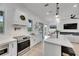 Modern kitchen with white cabinets, stainless steel appliances, and an island open to the living room at 6512 Simone Shores Cir, Apollo Beach, FL 33572