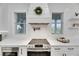 Modern kitchen features sleek white cabinets, stainless steel appliances, and stylish herringbone tile backsplash at 6512 Simone Shores Cir, Apollo Beach, FL 33572