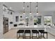Bright, modern kitchen with white cabinets, stainless steel appliances, a large island, and a cozy living area at 6512 Simone Shores Cir, Apollo Beach, FL 33572