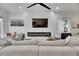 Modern living room featuring a cozy white couch, a fireplace, and a large television mounted on a shiplap wall at 6512 Simone Shores Cir, Apollo Beach, FL 33572