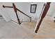Staircase with light hardwood floors, white risers and stringers, and a dark wood handrail at 6512 Simone Shores Cir, Apollo Beach, FL 33572