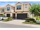 Beautiful townhome with a dark two-car garage, lush landscaping, and blue shutter accents at 6711 Rocky Park St, Tampa, FL 33625