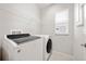 Laundry room features modern, front-loading washer and dryer and storage shelf at 6711 Rocky Park St, Tampa, FL 33625