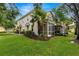 Townhouse backyard featuring a screened-in porch and well-manicured lawn with a palm tree at 7001 Interbay Blvd # 242, Tampa, FL 33616