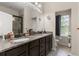 Double sink bathroom with a granite countertop, wood cabinets, and modern fixtures at 7001 Interbay Blvd # 242, Tampa, FL 33616