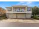 Three-story townhouse featuring a balcony above stone-accented three-car garages on a sunny day at 7001 Interbay Blvd # 242, Tampa, FL 33616