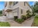 Side view of a townhome featuring a three-car garage, stone accents, and well-maintained landscaping at 7001 Interbay Blvd # 242, Tampa, FL 33616