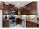 Kitchen featuring stainless steel appliances, dark wood cabinets, and granite countertops at 7001 Interbay Blvd # 242, Tampa, FL 33616