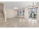 Open-concept living room with tile flooring, staircase, and sliding glass doors at 7001 Interbay Blvd # 242, Tampa, FL 33616