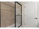 Modern tiled shower with a glass enclosure and dark trim at 7001 Interbay Blvd # 242, Tampa, FL 33616