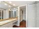 Bathroom vanity with a countertop, mirrored wall, and entry into a walk-in closet at 7300 Sun Island S Dr # 1505, South Pasadena, FL 33707