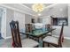 Cozy dining room with glass table and chairs, chandelier and views from the nearby living area at 7300 Sun Island S Dr # 1505, South Pasadena, FL 33707