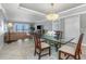 Dining room featuring a chandelier, glass table and chairs with views from the nearby living area at 7300 Sun Island S Dr # 1505, South Pasadena, FL 33707