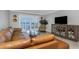 Comfortable living room features a modern entertainment center and sliding doors with a beautiful view at 7300 Sun Island S Dr # 1505, South Pasadena, FL 33707