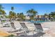 Community pool featuring lounge chairs and clear blue water surrounded by greenery at 7300 Sun Island S Dr # 1505, South Pasadena, FL 33707