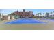 View of the blue, well-maintained tennis courts with the condo buildings and palm trees in the background at 7300 Sun Island S Dr # 1505, South Pasadena, FL 33707