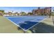 View of the blue, well-maintained tennis courts with the condo buildings and palm trees in the background at 7300 Sun Island S Dr # 1505, South Pasadena, FL 33707