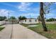 Exterior shot of home with a long driveway and mature landscaping at 7524 Tidewater Trl, Tampa, FL 33619