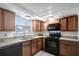 A kitchen with black appliances, tile floors, and brown cabinets at 7524 Tidewater Trl, Tampa, FL 33619
