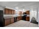 A kitchen with black appliances, tile floors, and brown cabinets at 7524 Tidewater Trl, Tampa, FL 33619