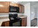 A kitchen with black appliances and brown cabinets at 7524 Tidewater Trl, Tampa, FL 33619