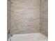 The shower is accented with beige marble look tile at 7524 Tidewater Trl, Tampa, FL 33619