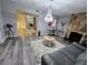 Bright living room featuring a stone fireplace, stylish chandelier, modern flooring, and contemporary decor at 8341 41St N Ave, St Petersburg, FL 33709