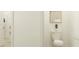 Bright bathroom featuring a toilet with white walls, modern minimalist design and a glimpse of a closet at 9583 Runaway Breeze Dr, Land O Lakes, FL 34637