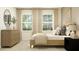 Bright bedroom with a wooden bed, a dresser, and a large window with neutral-toned curtains at 9583 Runaway Breeze Dr, Land O Lakes, FL 34637