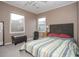 Bedroom with two windows, striped bedspread, gray headboard and upholstered ottoman at 1001 57Th N Ave, St Petersburg, FL 33703