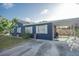 Charming blue home featuring a covered carport and well-maintained landscaping at 1001 57Th N Ave, St Petersburg, FL 33703