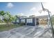 Blue home featuring a covered carport, well-maintained landscaping, and basketball hoop at 1001 57Th N Ave, St Petersburg, FL 33703