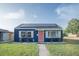 Charming blue home with solar panels, a pink door, and well-manicured lawn at 1001 57Th N Ave, St Petersburg, FL 33703