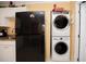 Efficient laundry area with stacked washer/dryer, sink and black refrigerator at 1001 57Th N Ave, St Petersburg, FL 33703