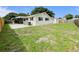 A view of the home's back exterior with a screened porch, patio, and grassy backyard at 1003 Cornwall Ct, Brandon, FL 33510