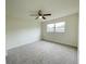 Spacious bedroom with plush carpet, a ceiling fan, and lots of natural light from the large window at 1003 Cornwall Ct, Brandon, FL 33510