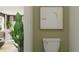 Modern bathroom with a toilet, decorative items, and a glimpse into the living area at 10113 Trumpet Honetsuckle Way, San Antonio, FL 33576