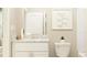 Bright bathroom features a white vanity with a granite countertop and minimalist artwork at 10186 Trumpet Honeysuckle Way, San Antonio, FL 33576