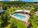 Aerial view features a sparkling community pool, lush landscaping and covered pavilion at 10707 Pegasus Valley Ct, Tampa, FL 33647