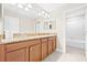 Bathroom with double vanity with stone countertops, dark cabinets, and a bright white tiled shower/tub combo at 10707 Pegasus Valley Ct, Tampa, FL 33647