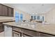 Close-up of the kitchen island featuring a sink, granite countertop, and an open view of the living space at 10707 Pegasus Valley Ct, Tampa, FL 33647