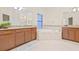 Luxurious main bathroom featuring double vanities, a garden tub, and tile flooring at 10707 Pegasus Valley Ct, Tampa, FL 33647