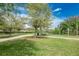 Grassy recreational area with mature trees, walking paths, and a blue sports court for basketball and other activities at 10707 Pegasus Valley Ct, Tampa, FL 33647