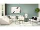 Comfortable living room with a sectional sofa, accent chairs, and modern artwork on a muted green wall at 10844 Fowlers Bluff Ct, Tampa, FL 33647