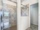 Bathroom with a sleek glass-enclosed shower featuring modern tile work and fixtures, as well as a doorway to the bedroom at 11100 Balfour St, Venice, FL 34293
