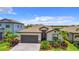 Beautiful single-Gathering home with a well-manicured lawn, paved driveway, and tropical landscaping at 11100 Balfour St, Venice, FL 34293