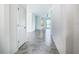 Bright hallway featuring gray tile floors and neutral walls, leading to various rooms at 11100 Balfour St, Venice, FL 34293