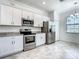 Modern kitchen with stainless steel appliances and white cabinetry at 11100 Balfour St, Venice, FL 34293