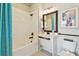 Bright bathroom with white tiled shower, blue curtain, and black fixtures at 11313 Hardwood Hammock Ln, Riverview, FL 33569