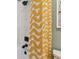 Close-up of white tiled tub/shower combo with oil rubbed bronze fixtures and yellow curtain at 11313 Hardwood Hammock Ln, Riverview, FL 33569